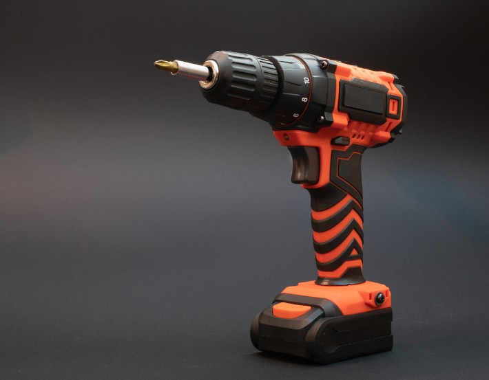 a cordless drill with red and black designs