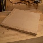 A square planing board, bench hook style.