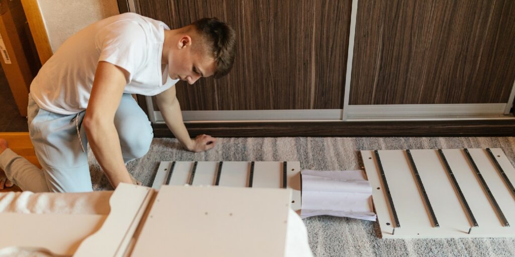 Teenager boy putting furniture together in his bedroom