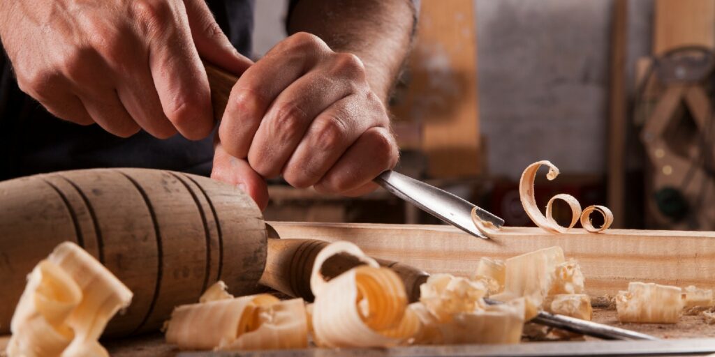 Hands of craftsman carve with a gouge