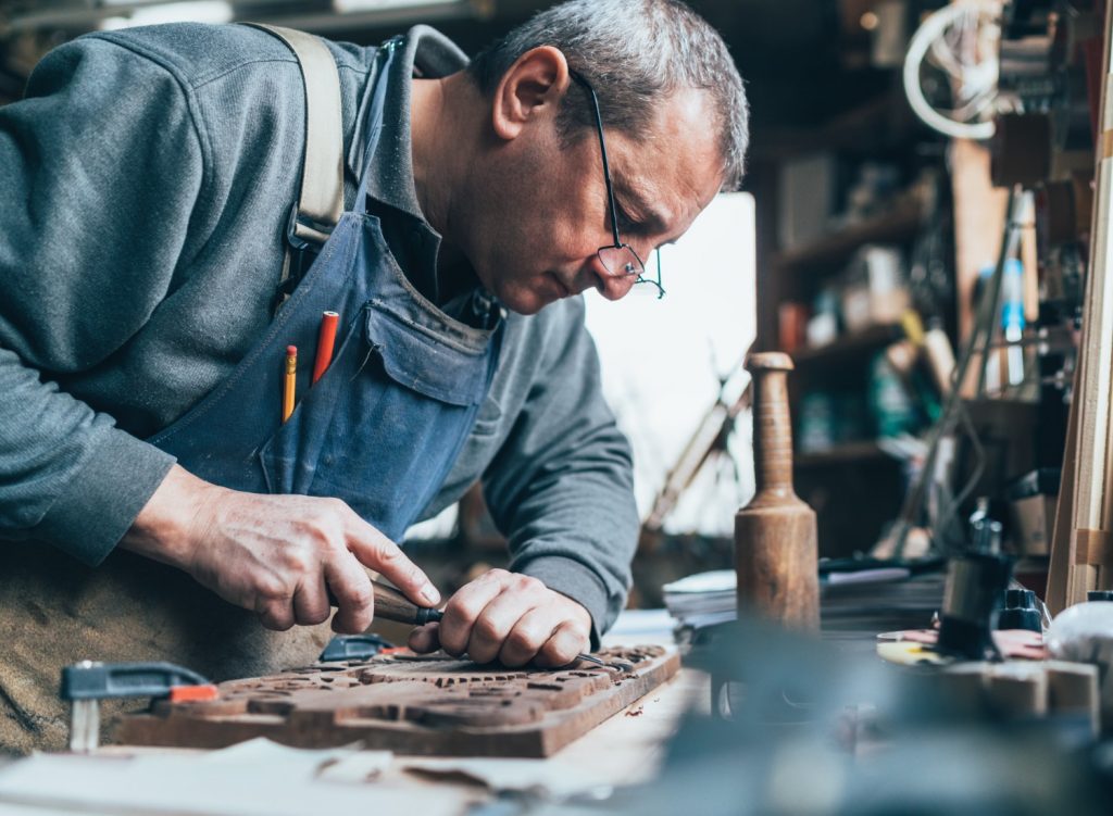 Man carving wood in shop
