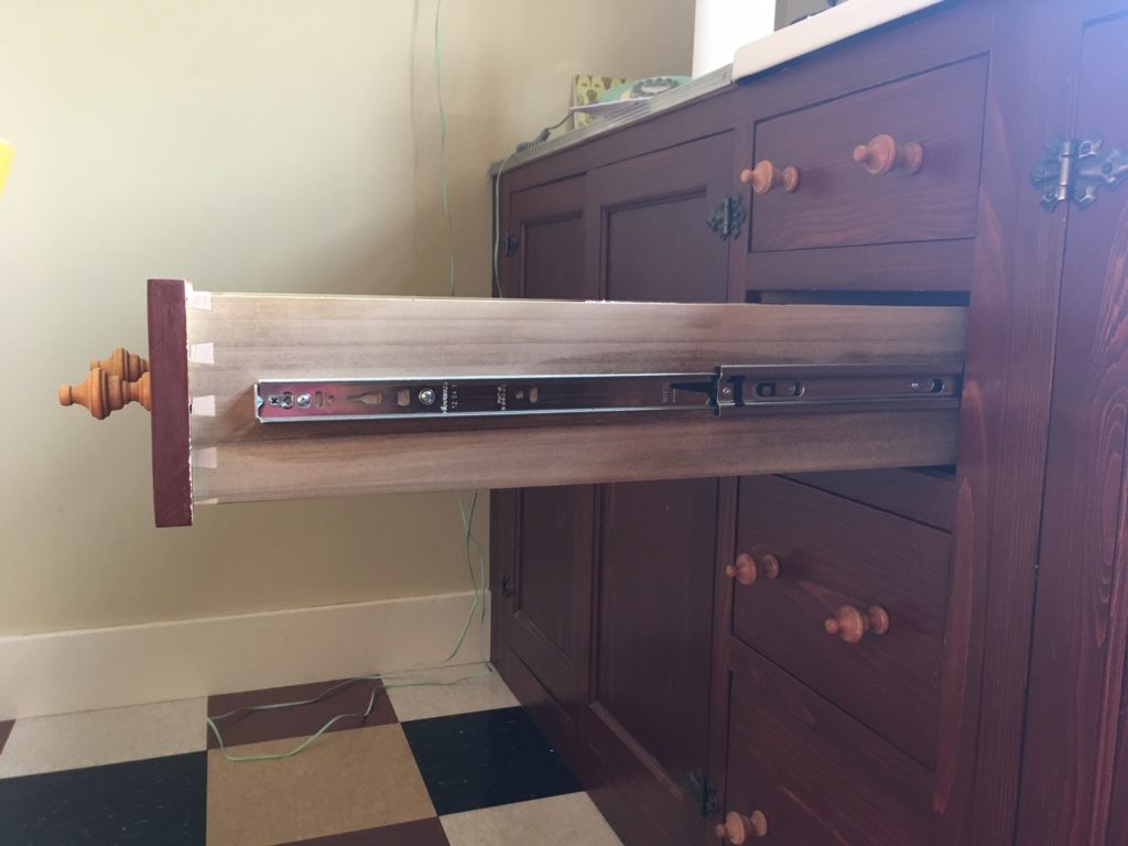 dresser drawer with metal glide with pull-out guards (plastic ، visible; these are plastic stops at the edge of the drawer)