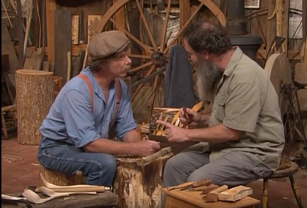 A screen grab from "The Woodwright's Shop Season 31, Episode 8, featuring Peter Follansbee showing Roy Underhill how to carve a Swedish-style spoon.