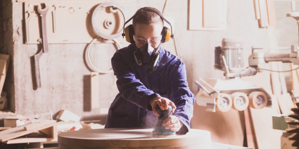 Safety in Woodworking. Female Carpenter in Googles and Dust Mask
