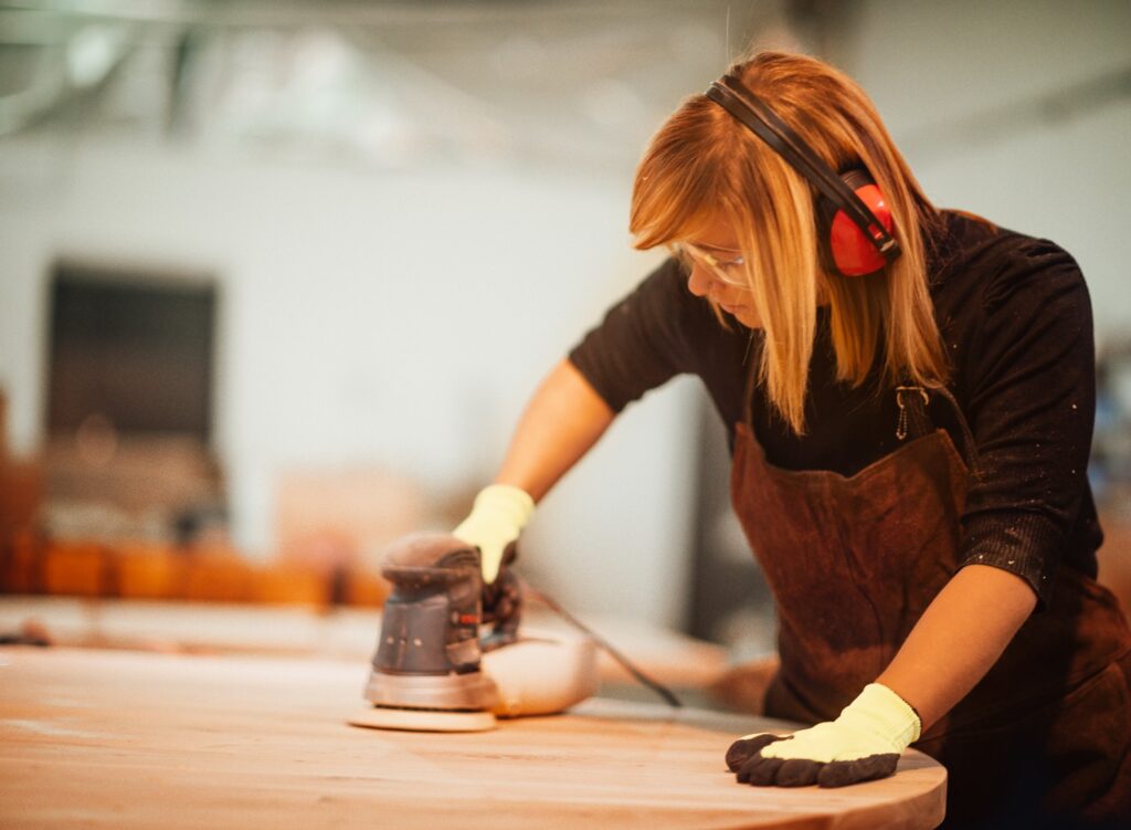 Woman sanding a wooden table