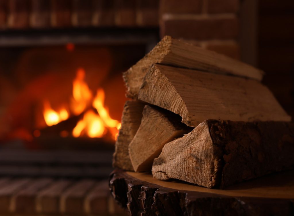 Firewood next to a fireplace